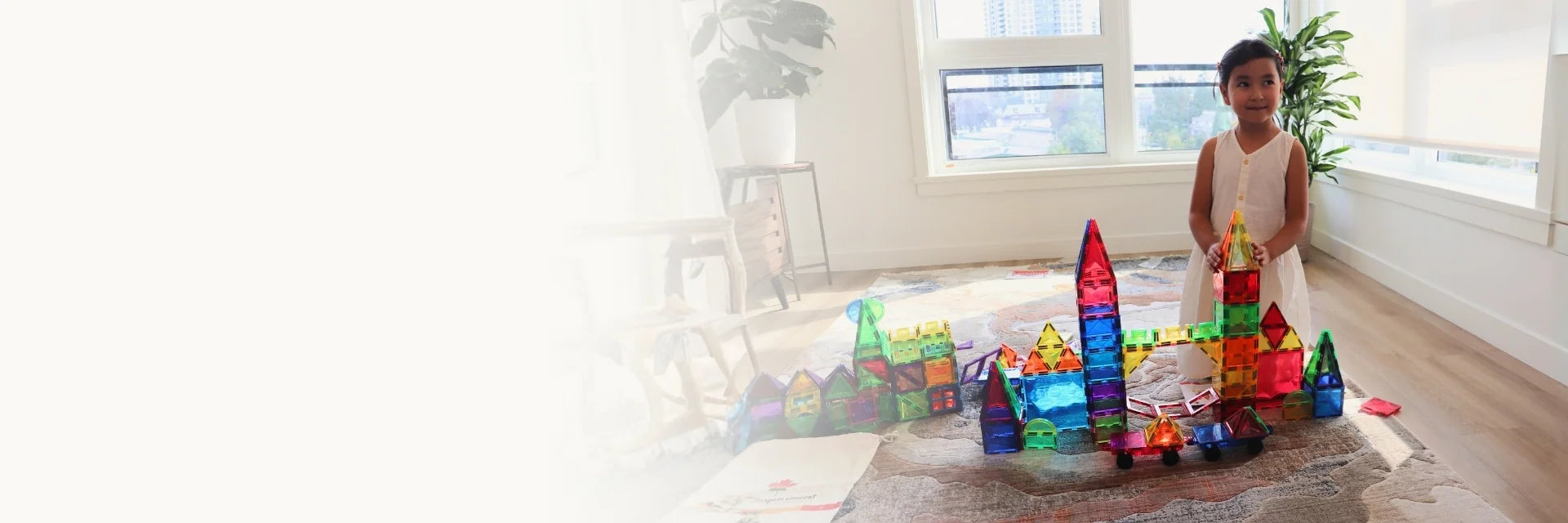 Child building a colourful Tessella magnetic tiles castle
