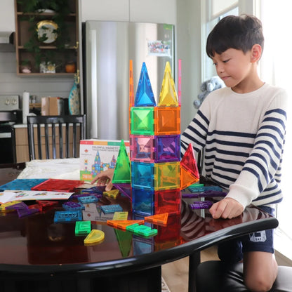 Child building a tall tower with Tessella Explorer Set – 78 Piece Magnetic Tiles on a table, colorful STEM educational toy for kids ages 3+, compatible with Connetix, PicassoTiles, Magna-Tiles.