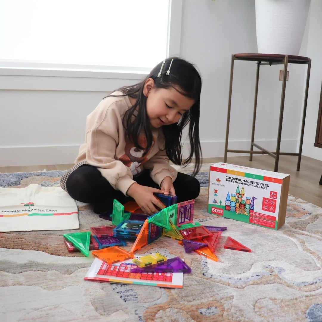 Child exploring Tessella Spark Set – 50 Piece Magnetic Tiles on the floor, colorful STEM building toy for kids ages 3+, educational play compatible with Connetix, PicassoTiles, Magna-Tiles.